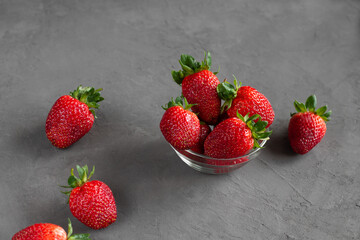 Strawberries in a bowl on a gray background