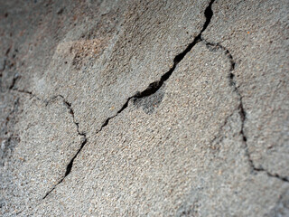 plastered textured wall with cracks and pebbles