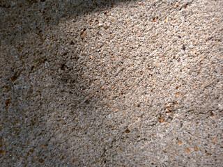 plastered textured wall with cracks and pebbles