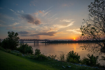 Sunset over Mississippi river in Memphis, Tennessee with tree in foreground
