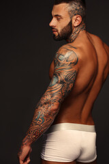 Sexy closeup portrait of handsome topless male model with beautiful eyes. Sexy man or muscular macho, bodybuilder, with muscle torso, body with six packs and abs poses on in white panties