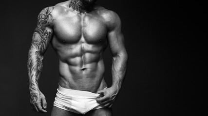 Sexy closeup portrait of handsome topless male model with beautiful eyes. Sexy man or muscular macho, bodybuilder, with muscle torso, body with six packs and abs poses on black background