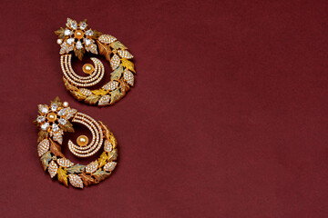 Glamorous antique Golden pair of earrings on red background. Luxury female jewelry, Indian traditional jewellery, kundan earring,Bridal Gold earrings wedding jewellery,Vintage earring