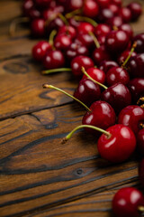 ripe, red, farm cherries on a brown wooden background
