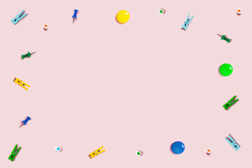Pink background with writing materials. Back to school flat lay with blue, yellow and green school supplies on pink background.