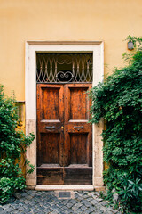 Fototapeta na wymiar old wooden door in yellow wall of house