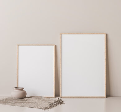 Frame mock up in empty room on beige wall, two wooden frames standing on white floor, 3D render