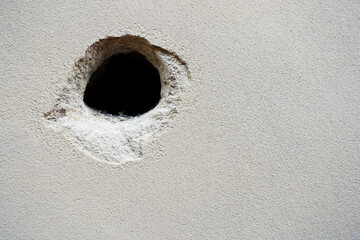 Cracks holes on the cement wall Caused by drilling To put the plumbing tube in the house