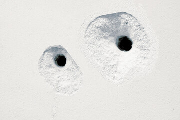 Cracks Holes on the white cement wall caused by drilling to put pipes Install the water system of...