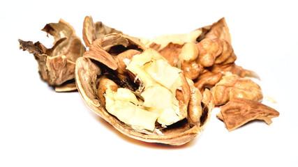 Close-up of crushed walnuts with nutshell isolated on white background