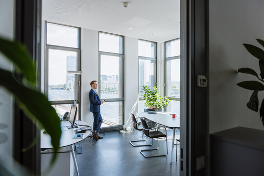 Businessman standing at thw window in office