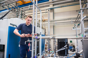 Craftsman working at pipework in a factory