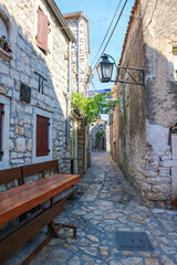 Fototapeta na wymiar Pakostane/Croatia-July 24,2017: Narrow, old, stone paved streets and houses of dalmatian town by the Adriatic sea