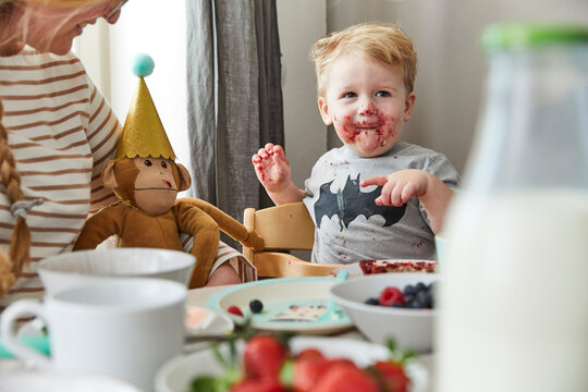 Portrait of smeared little boy at breakfast table