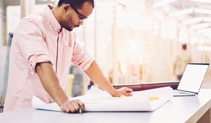 Skilled main architect of corporation looking on building plan thinking of opportunities for...