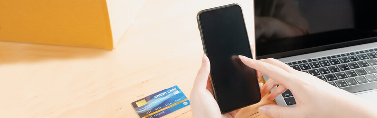 web banner payment by smartphone and laptop  in online seller woman's hand 