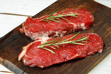 Barbecue veal steaks with rosemary on wooden board