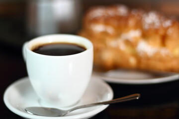 Coffee cup with espresso and eclair