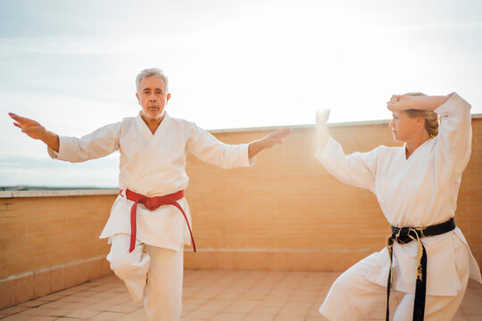 Woman with teacher during karate training on terrace