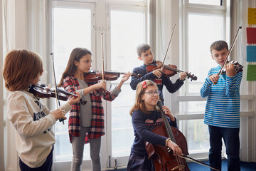 Group of children playing violin during a lesson