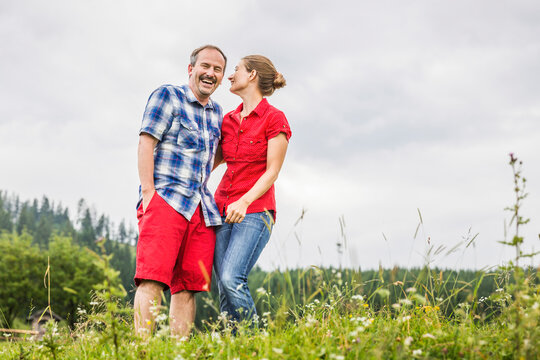 Happy couple standing on a meadow in the mountains, Achenkirch, Austria