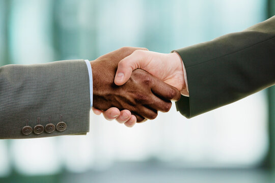 Interracial handshake on business background