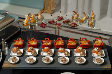 Salmon rolls, with cream cheese and butter, sprinkled with sesame seeds. Nearby are cheese balls in sesame seeds.