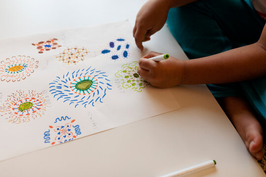 Crop view of little boy drawing flowers