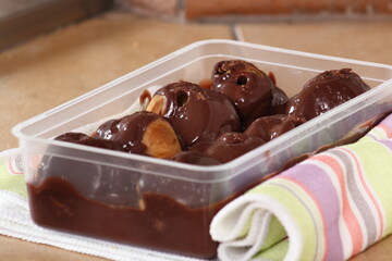 Box with profiterole with chocolate ganache frosting.