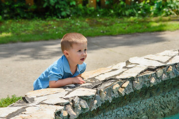 Little boy at the public fountain playing with water