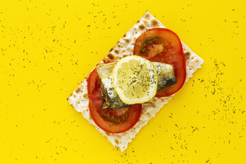 Salty crackers with sardine, tomato and lemon from above