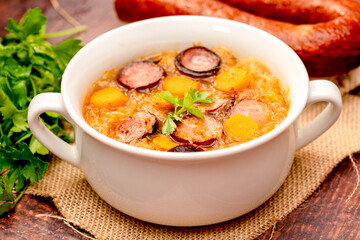 sauerkraut soup in a bowl on a wooden table