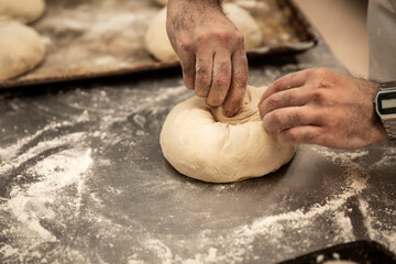 Obraz premium hands of the master baker in bread production