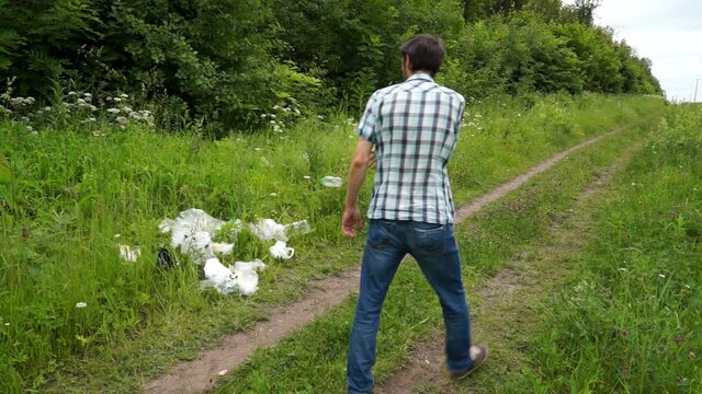 a man throws a plastic bottle in the woods. Environmental pollution with plastic. Caring for nature.