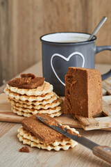 Fototapeta na wymiar Viennese waffles with Norwegian brunost cheese with a cup of coffee in the background. Breakfast with Traditional Scandinavian brown cheese