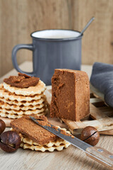 Viennese waffles with Norwegian brunost cheese with a cup of coffee in the background. Breakfast with Traditional Scandinavian brown cheese