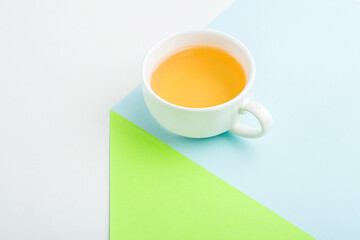 Minimalistic geometric composition with cup of asian green tea on blue and green background. Fresh spring organic herbal, green drink. Copy space for text