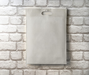 An empty, clean cloth bag against a brick wall. Layout for your ad. Stylized stock photos. Banner.