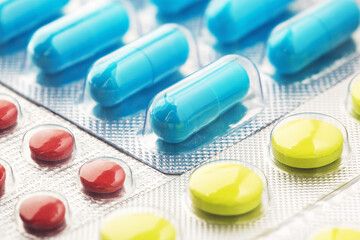 pile of medical pills  in red, blue colors in  silver plastic packaging