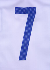White football shirt with blue number 7 seven on it. sports wear background.