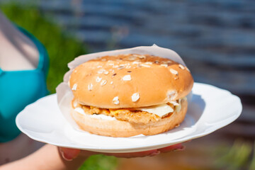 a mouth-watering Burger with a cutlet on the plate. bun with seeds