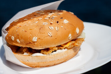 a mouth-watering Burger with a cutlet on the plate. bun with seeds