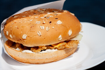 a mouth-watering Burger with a cutlet on the plate. bun with seeds