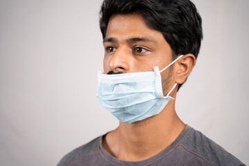 young man wearing medical mask below nose - concept showing of improper way of using face masks...