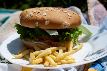 hamburger with lettuce on a plate with French fries