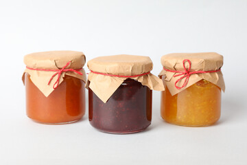 Fototapeta na wymiar Glass jars with jam on white background. Sweet food