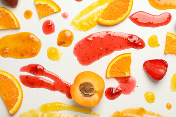 Apricot, strawberry, orange and jams on white background