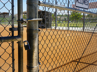 Baseball Diamond through a locked chain link gate.