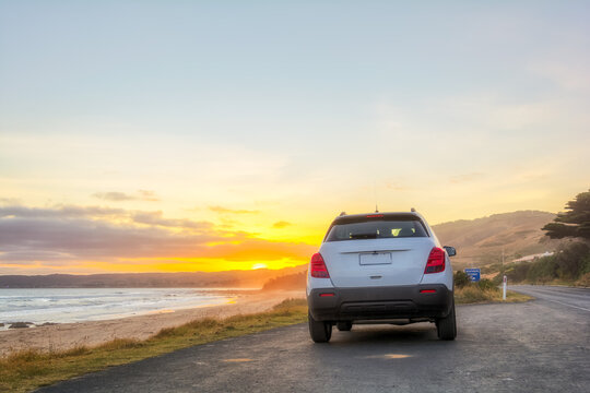 Fototapeta Rear view of car at sunset