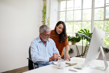 Two professional business people, sharing ideas in an open-plan studio office